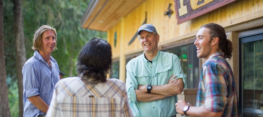 rogue river oregon hiking trip a group of people talking in front of a large lodge building