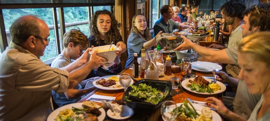 rogue family river rafting a group of people sharing a meal and passing food between each other